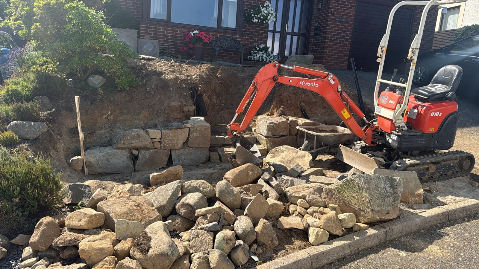 Stone retaining walls and steps under construction in Criccieth